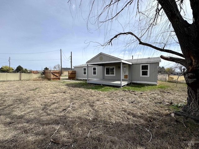 rear view of house with a deck and fence
