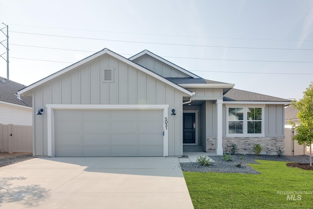 ranch-style home with an attached garage, a shingled roof, board and batten siding, concrete driveway, and a front yard
