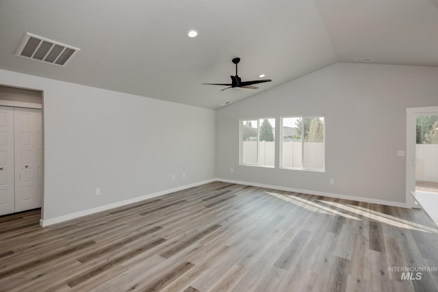 unfurnished living room featuring wood finished floors, visible vents, vaulted ceiling, ceiling fan, and baseboards