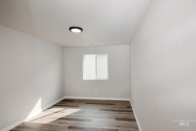 unfurnished room with wood finished floors and baseboards
