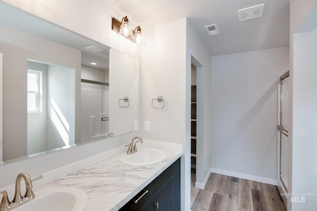 full bath with a sink, a shower stall, and visible vents