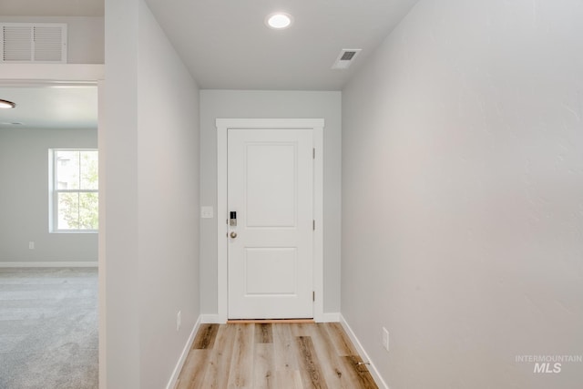 doorway with baseboards and visible vents