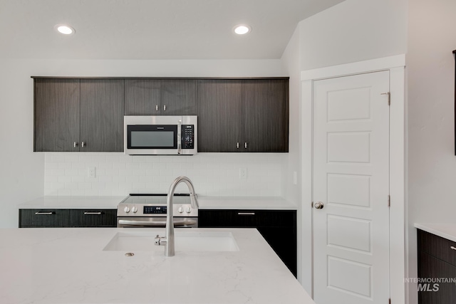 kitchen with backsplash, recessed lighting, appliances with stainless steel finishes, and a sink