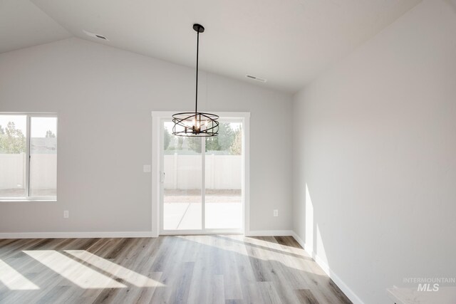 unfurnished dining area with a chandelier, visible vents, wood finished floors, and lofted ceiling