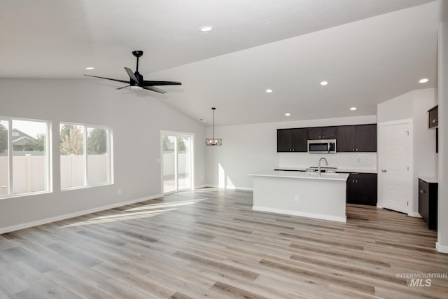 unfurnished living room featuring a ceiling fan, light wood-style floors, recessed lighting, and vaulted ceiling