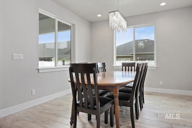 dining area with a chandelier, a mountain view, and light hardwood / wood-style floors