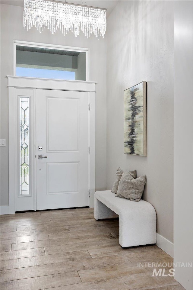 foyer entrance featuring an inviting chandelier and light hardwood / wood-style flooring