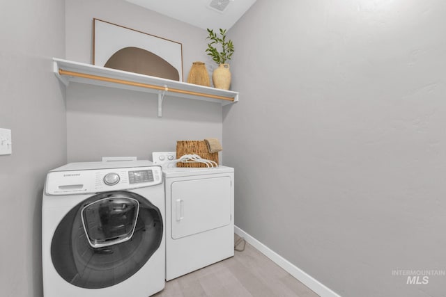 12041 W Ardyce, Boise, ID 83713 - laundry area with washer and clothes dryer, light wood finished floors, and baseboards