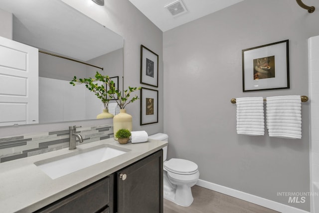 12041 W Ardyce, Boise, ID 83713 - full bath featuring vanity, toilet, backsplash, baseboards, and wood finished floors