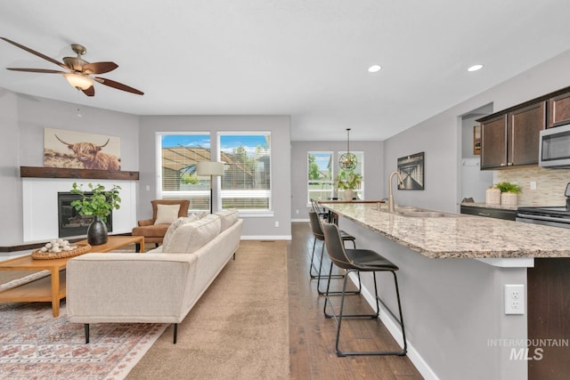12041 W Ardyce, Boise, ID 83713 - living room featuring dark wood-style floors, recessed lighting, a glass covered fireplace, ceiling fan, and baseboards