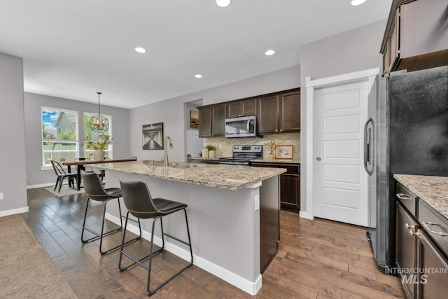 12041 W Ardyce, Boise, ID 83713 - kitchen featuring stainless steel appliances, a sink, dark wood-style floors, dark brown cabinetry, and tasteful backsplash