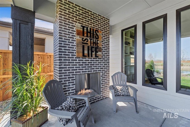 view of patio featuring a porch and exterior fireplace