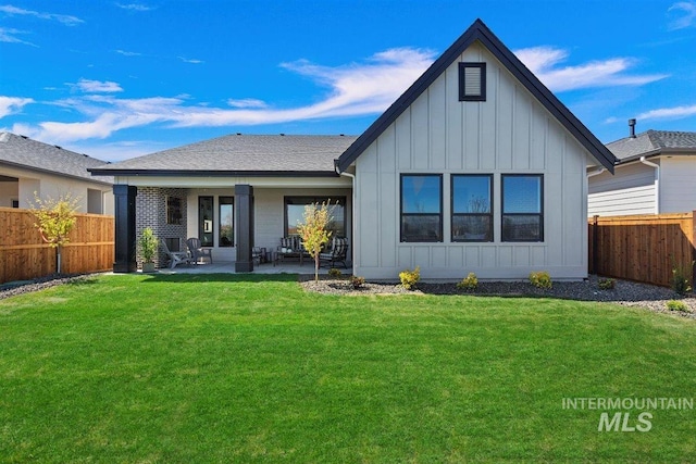 rear view of house featuring a yard and a patio