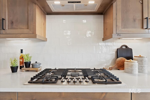 kitchen featuring decorative backsplash, ventilation hood, and stainless steel gas cooktop