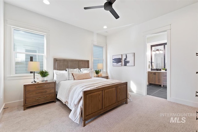 carpeted bedroom featuring ceiling fan and ensuite bath