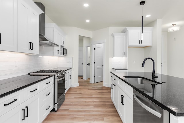 kitchen featuring hanging light fixtures, stainless steel appliances, decorative backsplash, white cabinetry, and sink