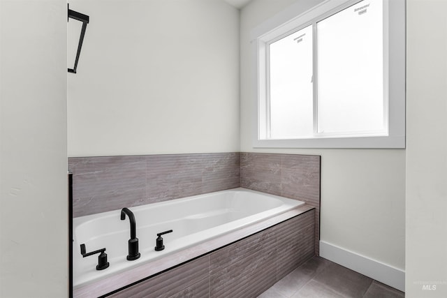 bathroom featuring tile patterned flooring and tiled bath