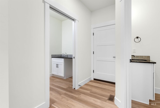 hall with light wood-type flooring and sink