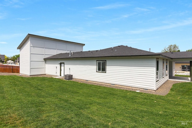 rear view of house featuring a yard and central AC