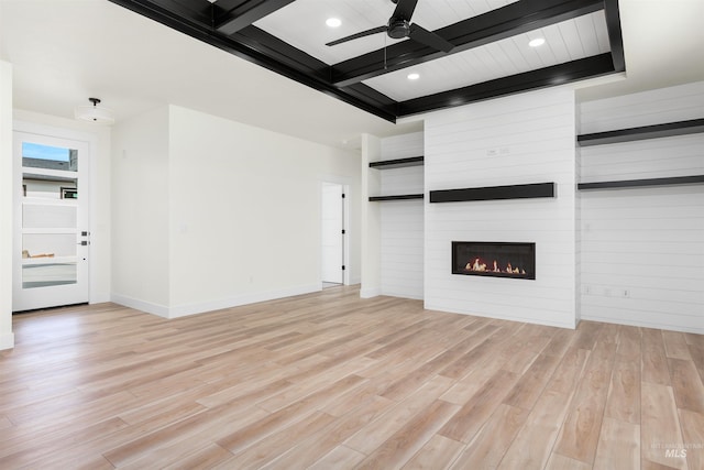 unfurnished living room featuring a fireplace, ceiling fan, light hardwood / wood-style flooring, and beamed ceiling