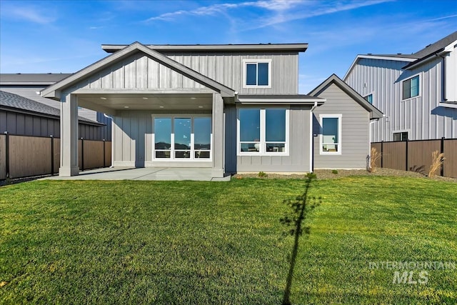 back of property with a patio and a lawn