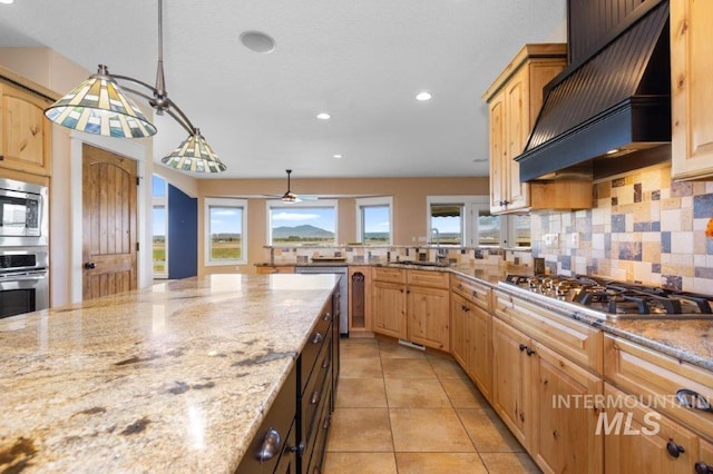 2600 W S Slope Rd, Emmett, ID 83617 - kitchen with custom exhaust hood, appliances with stainless steel finishes, tasteful backsplash, a sink, and light stone countertops