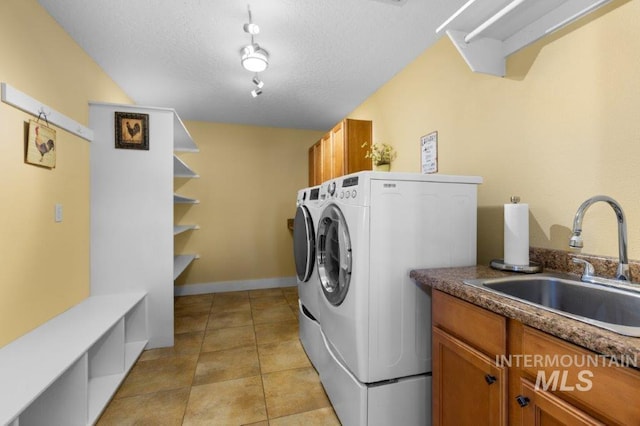 2600 W S Slope Rd, Emmett, ID 83617 - laundry area with separate washer and dryer, cabinet space, light tile patterned floors, and a textured ceiling
