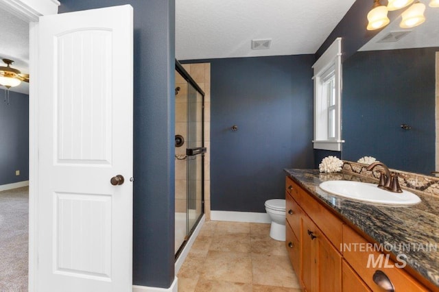 2600 W S Slope Rd, Emmett, ID 83617 - full bathroom with baseboards, a stall shower, vanity, toilet, and a textured ceiling