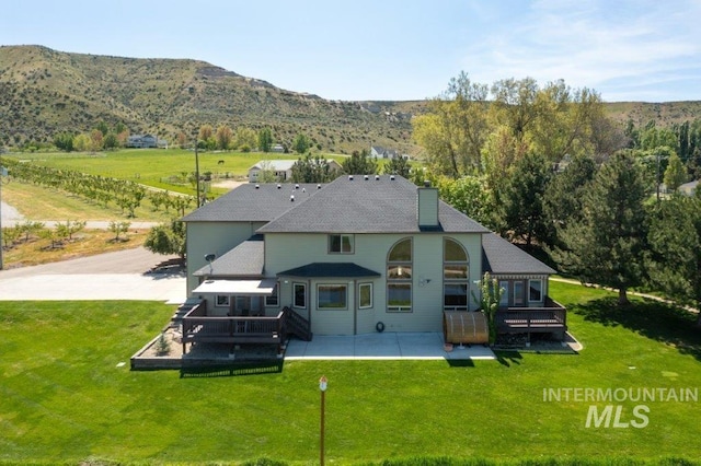 2600 W S Slope Rd, Emmett, ID 83617 - back of house featuring a deck with mountain view, a patio area, a yard, and a chimney