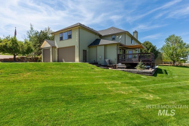 2600 W S Slope Rd, Emmett, ID 83617 - back of property with a deck, a lawn, a chimney, and an attached garage