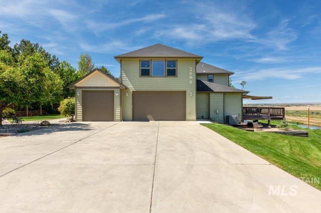 2600 W S Slope Rd, Emmett, ID 83617 - traditional-style home featuring concrete driveway, central AC unit, a front yard, a garage, and a wooden deck