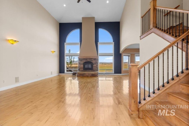 2600 W S Slope Rd, Emmett, ID 83617 - unfurnished living room with a towering ceiling, a ceiling fan, plenty of natural light, hardwood / wood-style flooring, and stairs