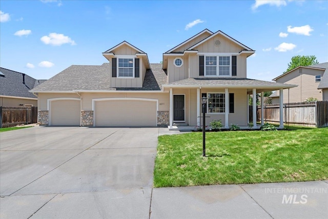 6311 S Solar Way, Boise, ID 83709 - view of front of home featuring a garage, board and batten siding, driveway, stone siding, and covered porch