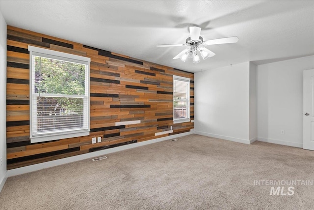 6311 S Solar Way, Boise, ID 83709 - spare room with wood walls, a ceiling fan, carpet floors, and baseboards