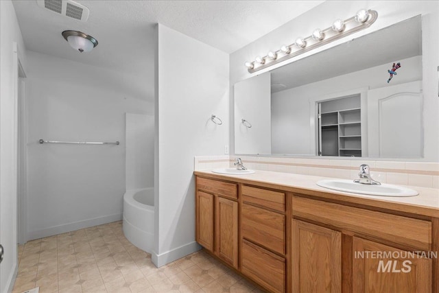 6311 S Solar Way, Boise, ID 83709 - bathroom featuring double vanity, baseboards, and a textured ceiling