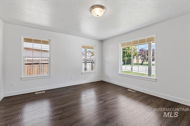 6311 S Solar Way, Boise, ID 83709 - spare room with a textured ceiling, dark wood finished floors, and baseboards
