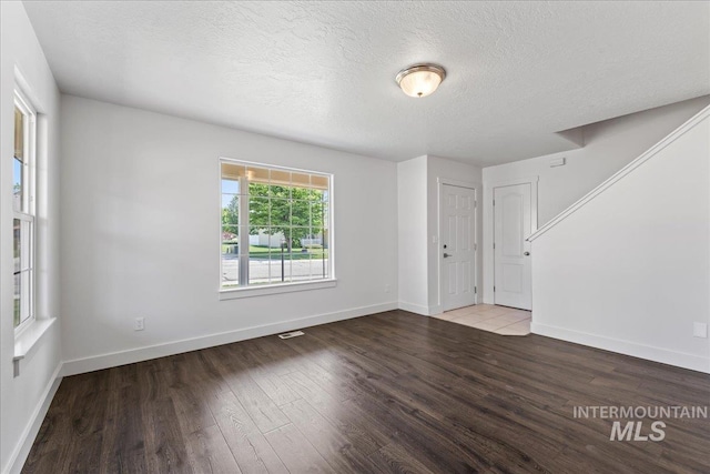 6311 S Solar Way, Boise, ID 83709 - unfurnished room with wood finished floors, a textured ceiling, and baseboards