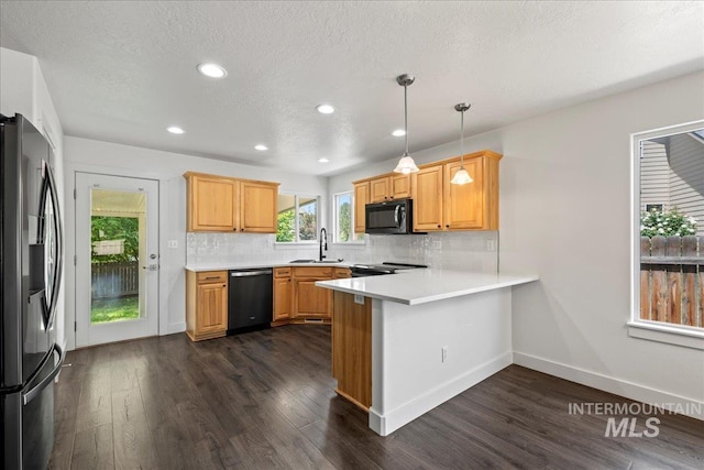 6311 S Solar Way, Boise, ID 83709 - kitchen with stainless steel fridge with ice dispenser, dishwashing machine, black microwave, a peninsula, and a sink