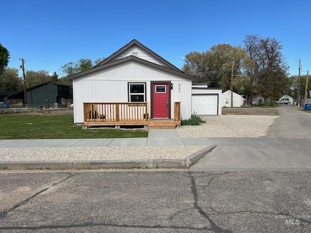 bungalow-style home with driveway, a front yard, and covered porch
