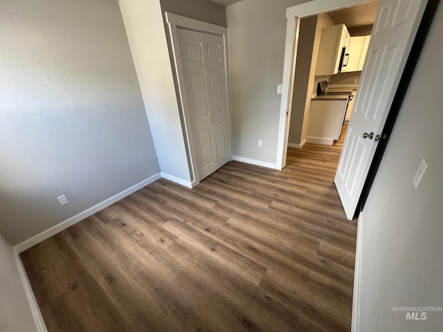 unfurnished bedroom with baseboards and wood finished floors
