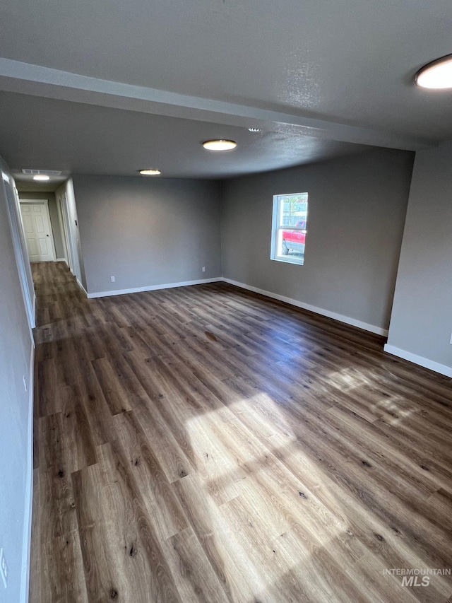 spare room with baseboards and dark wood finished floors