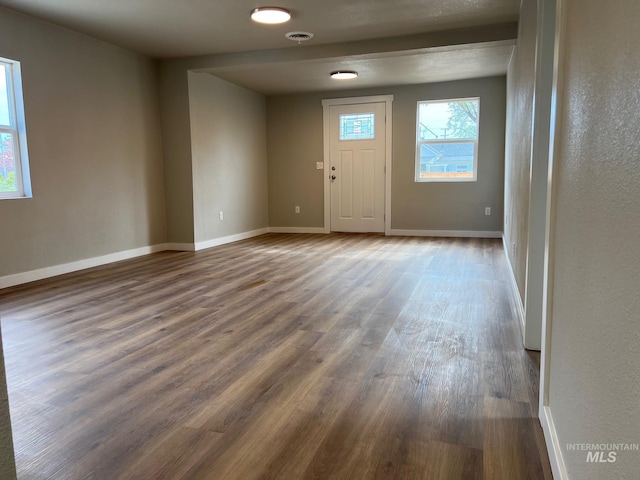 foyer featuring baseboards and wood finished floors