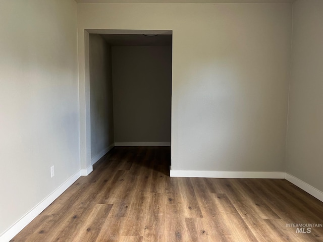 unfurnished room featuring baseboards and wood finished floors