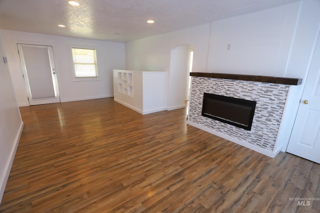 unfurnished living room featuring a textured ceiling and dark wood-type flooring