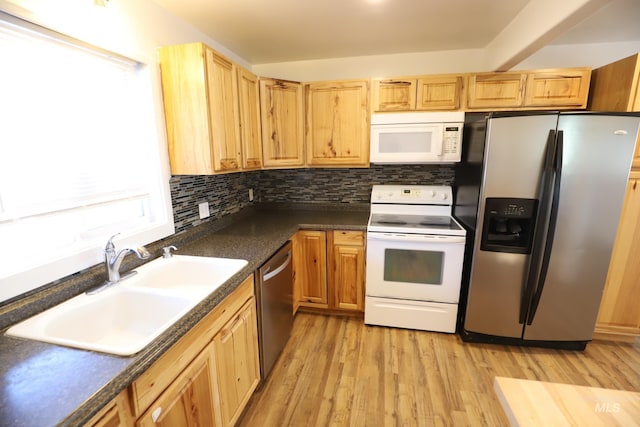 kitchen with stainless steel appliances, tasteful backsplash, light hardwood / wood-style floors, and sink