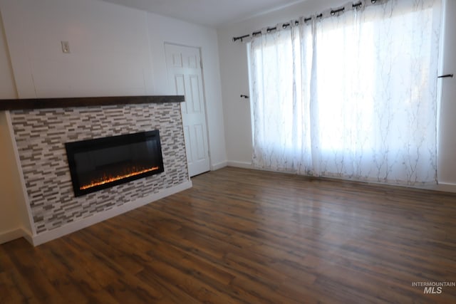 unfurnished living room with dark hardwood / wood-style flooring and a fireplace