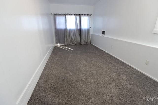 empty room with dark colored carpet