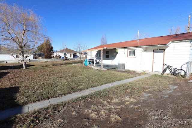 back of property with a lawn and central air condition unit