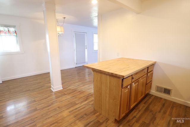 kitchen featuring dark wood-type flooring, wooden counters, decorative light fixtures, a notable chandelier, and kitchen peninsula