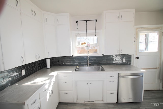 kitchen featuring light countertops, pendant lighting, white cabinets, and stainless steel dishwasher